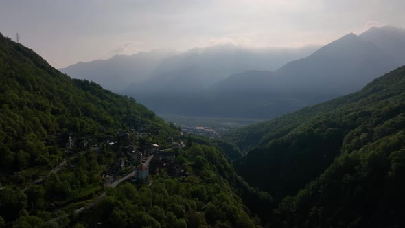 Small southern Italian alp village in bright evening sunlight glow; drone