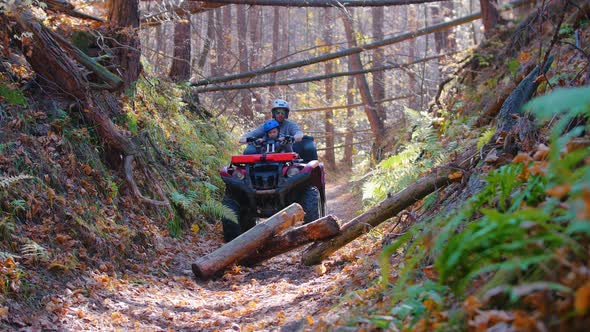 Outdoor Activity - Man with His Kid Riding ATVs in the Forest - Riding on Obstacle and Removing It