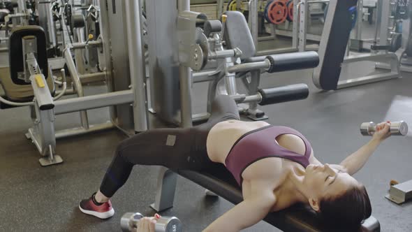 Seductive Sportswoman Doing Dumbbell Flyes