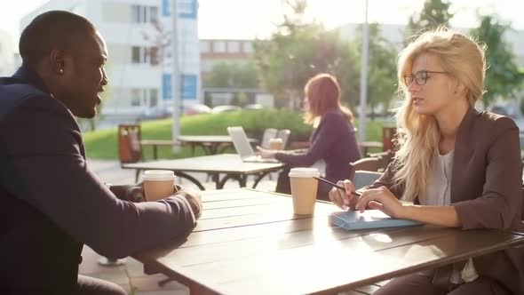 Multiethnic Colleagues Talking over Cup of Coffee