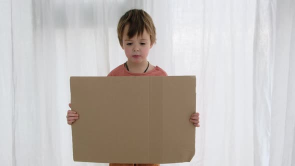 Upset Boy Holds Cardboard Sheet with Space for Template