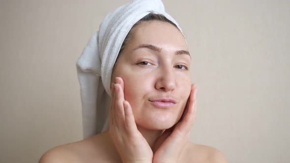 Young Woman with a White Towel on Head Stroking Face