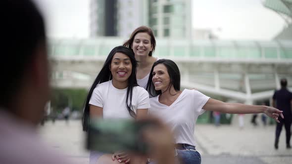 Smiling Women Posing for Photo While Sitting on Square