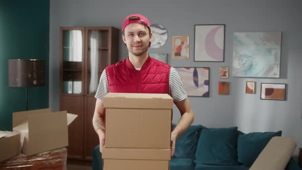 Delivery Man Holding Carton in New Apartment and Crossing Hands