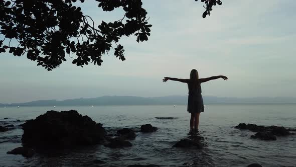 A Woman Enjoys a Sunset on the Beach