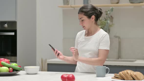 Indian Woman Taking Picture of Fruits on Smartphone in Kitchen