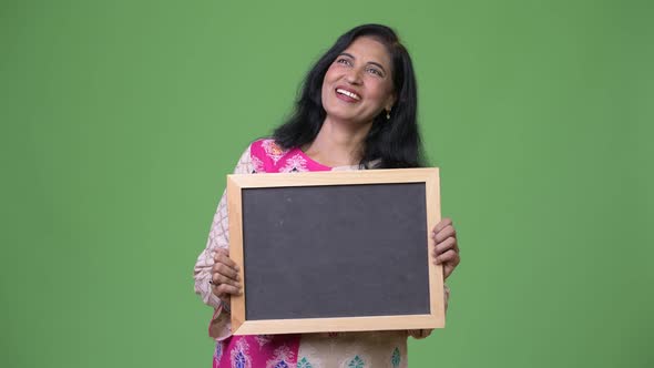 Mature Happy Beautiful Indian Woman Showing Blackboard While Thinking