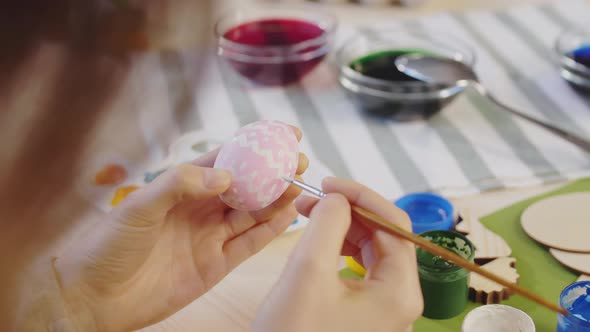 Unrecognizable Woman Painting Pattern on Easter Egg