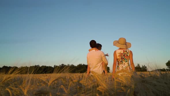 Family Walking in Field at Sunset