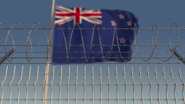 Waving Flag of New Zealand Behind Barbed Wire
