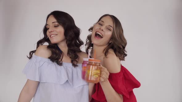 Two Young Sisters Drinking Fresh Orange Juice