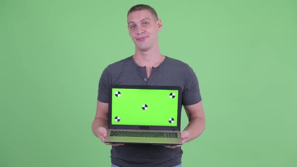 Stressed Young Man Showing Laptop and Getting Bad News