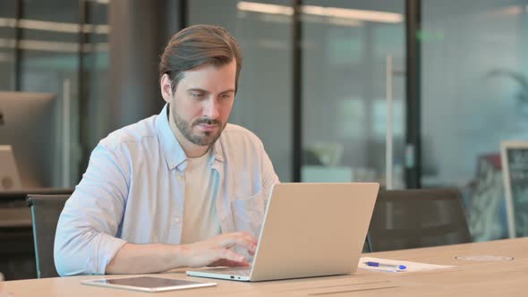 Successful Mature Adult Man Celebrating on Laptop in Office