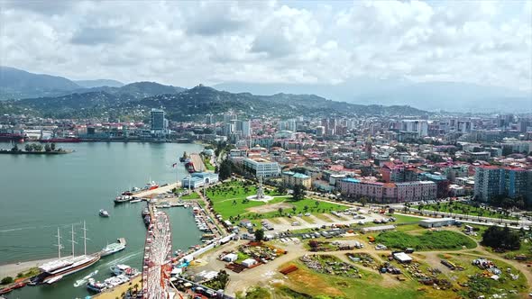 Aerial drone view of the coastline in Batumi, Georgia. Black sea, buildings, sea port, greenery and 