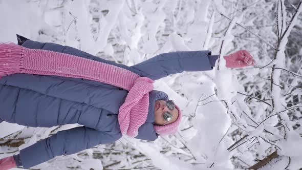 Woman in Pink Clothes a Scarf and a Knitted Hat Stands By a Tree