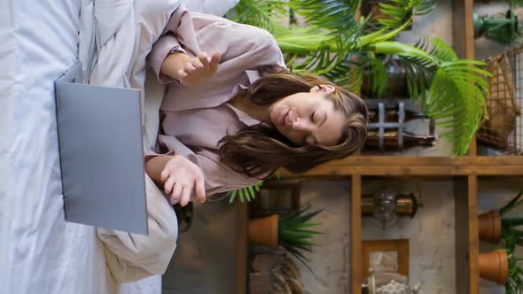 Vertical Video of a Woman in Front of a Laptop Monitor in Bed