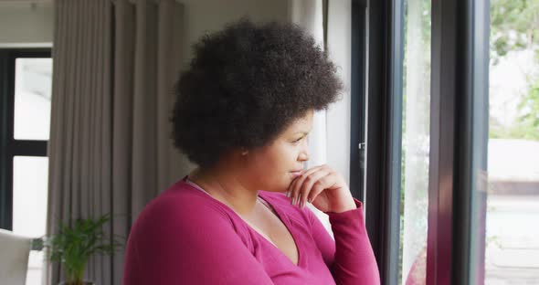Video of thoughtful plus size african american woman looking outside window