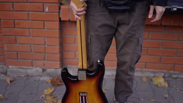 Man with a Guitar Smiling on the Street