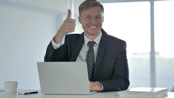 Thumbs Up By Businessman Looking at Camera