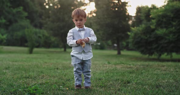 Cute Small Boy in a Casual Suit Eating His Snacks