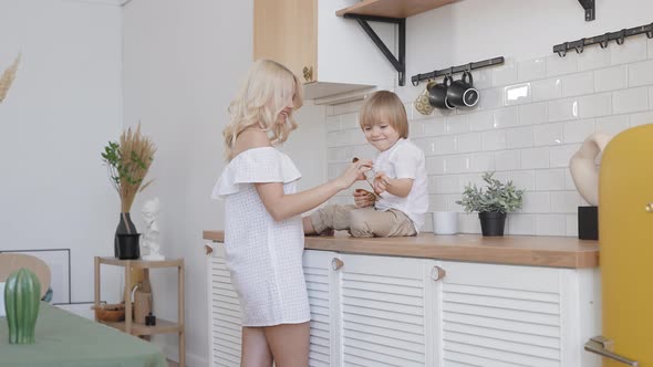 Blonde Woman with Her Son in the Kitchen