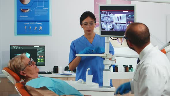 Doctor Pointing on Digital Screen Showing Dental Implants