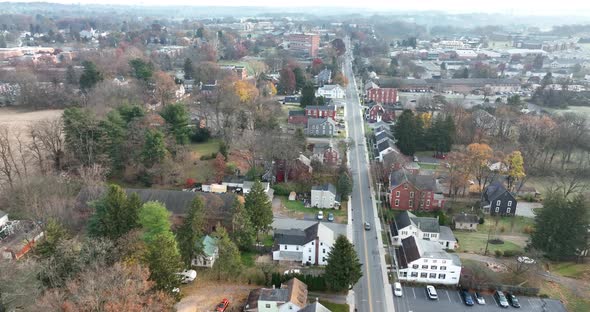 Neighborhood in USA during late autumn season. Aerial tracking shot as car travels through small tow