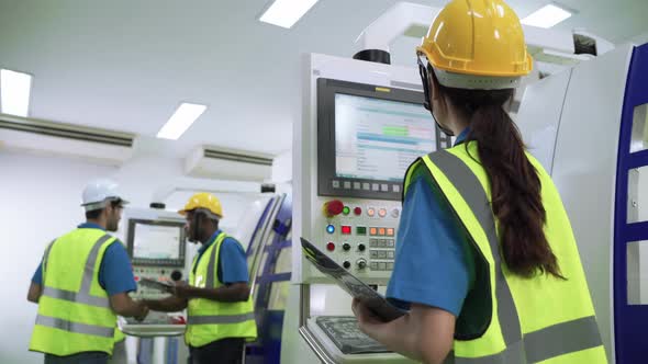 Factory engineers patrolling the workers who control the machine control panel