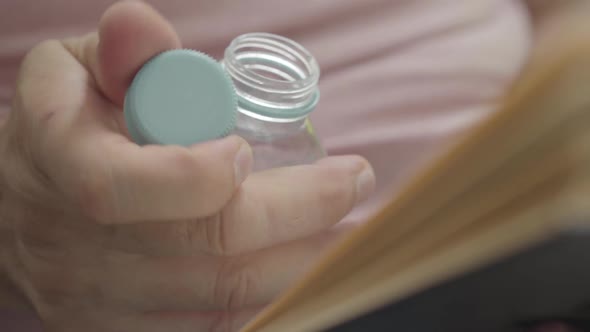 Male Hand Unscrews the Cap of a Plastic Bottle. The Man Drinks Water and His Hand Again Turns the