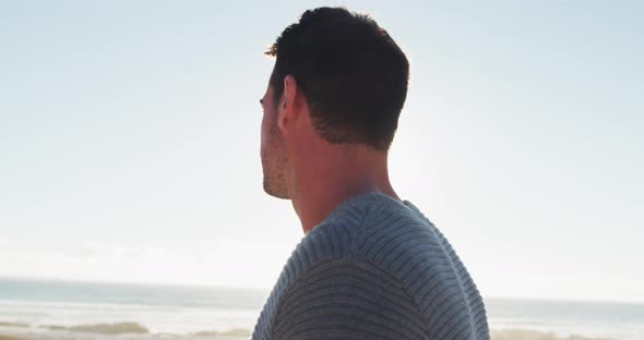 Happy caucasian man standing and smiling by the sea