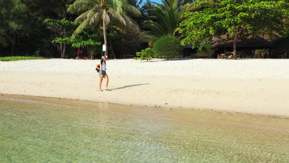 Ladies sunbathing on beautiful coastline beach lifestyle by blue sea with white sandy background of 