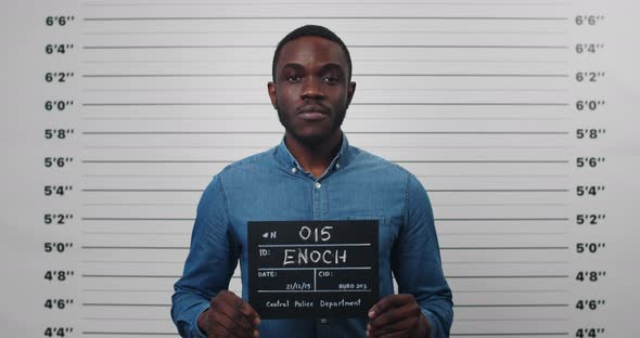 Portrait of Afro American Male Person Holding Sign for Photo in Police Department