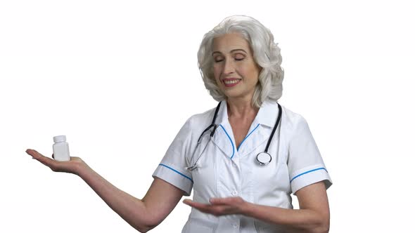 Female Doctor Showing Pills on White Background alt