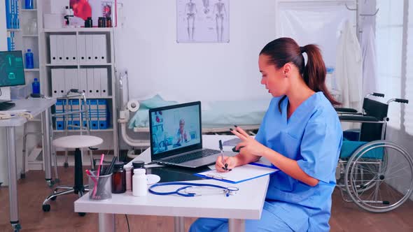 Assistant Taking Notes Listening Advice of Remote Doctor