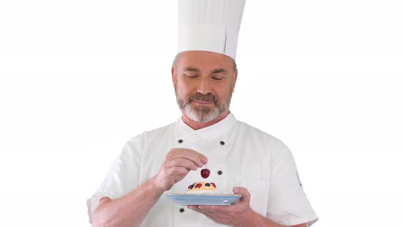 Chef Putting Cherry on Top of the Cake Before Serving It Icing on the Cake on White Background.