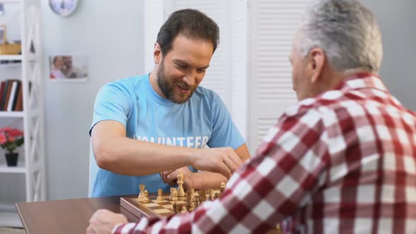 Middle Aged Male Volunteer Playing Chess With Elderly Man in Nursing Home, Hobby