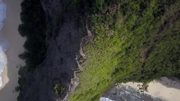 Daring aerial view flight very high drone shot from above path way edge cliffKelingking Beach at Nu