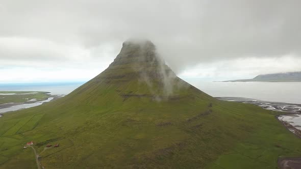 Kirkjufell mountain shrouded in clouds, Iceland. Aerial drone ascendent