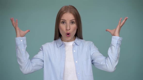 Young ginger woman in casual clothes making brain explosion gesture on blue wall background