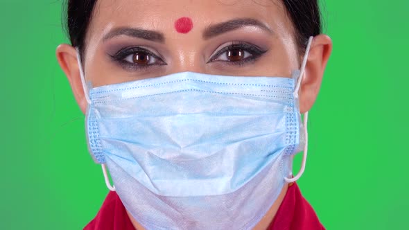 Portrait of Beautiful Indian Girl in a Protective Medical Mask, Looking at the Camera. Green Screen