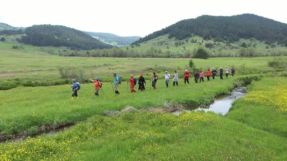 Group Of People Trekking In Meadow