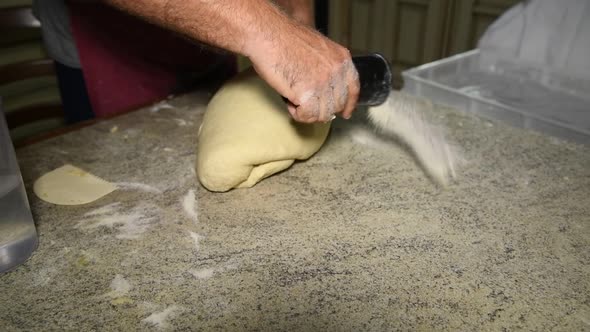 man putting a flour on the stone table to knead the dough for homemande bread