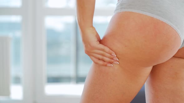 Woman Compressing the Skin of the Buttocks Checking for Cellulite and Excess Subcutaneous Fat