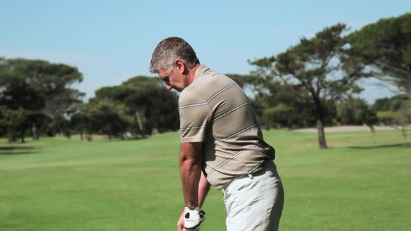 Mature man playing golf on golf course