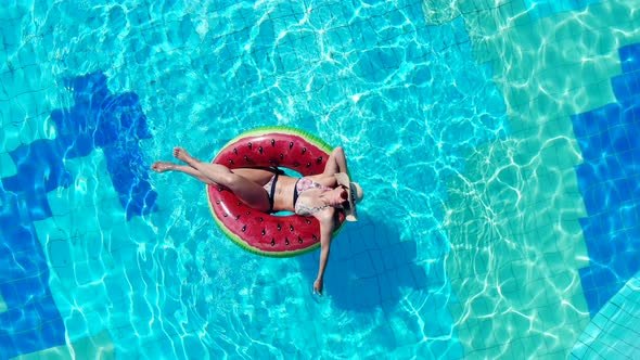 One Woman Enjoys Pool Water While Floating on a Rubber Ring