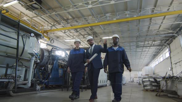  Male Manufacturing Engineer and Workers Walking through Plant