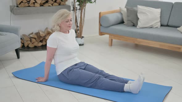 Senior Old Woman Doing Stretches on Yoga Mat at Home