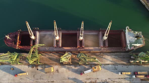 Aerial View of Big Cargo Ship Bulk Carrier is Loaded with Grain of Wheat in Port at Sunset