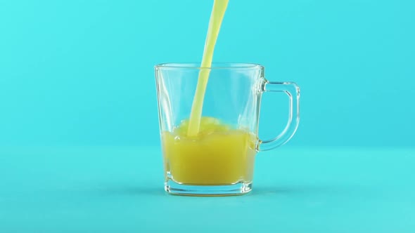 Slow Motion Close-up Shot of Fruit Orange Multifruit Juice Cold Beverage Drink Pooring Into Glass