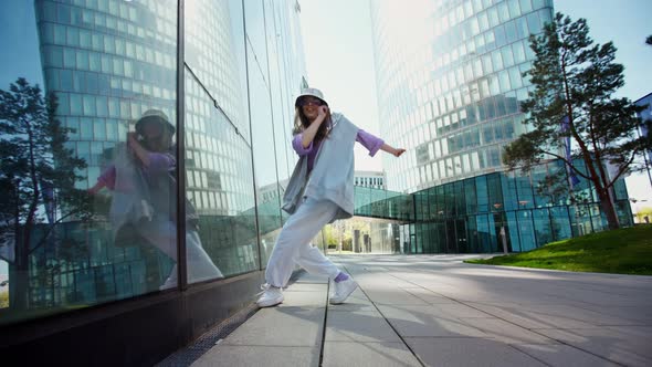 Active Urban Cute Girl in Hip Hop Hoodie Dancing Whit City Background